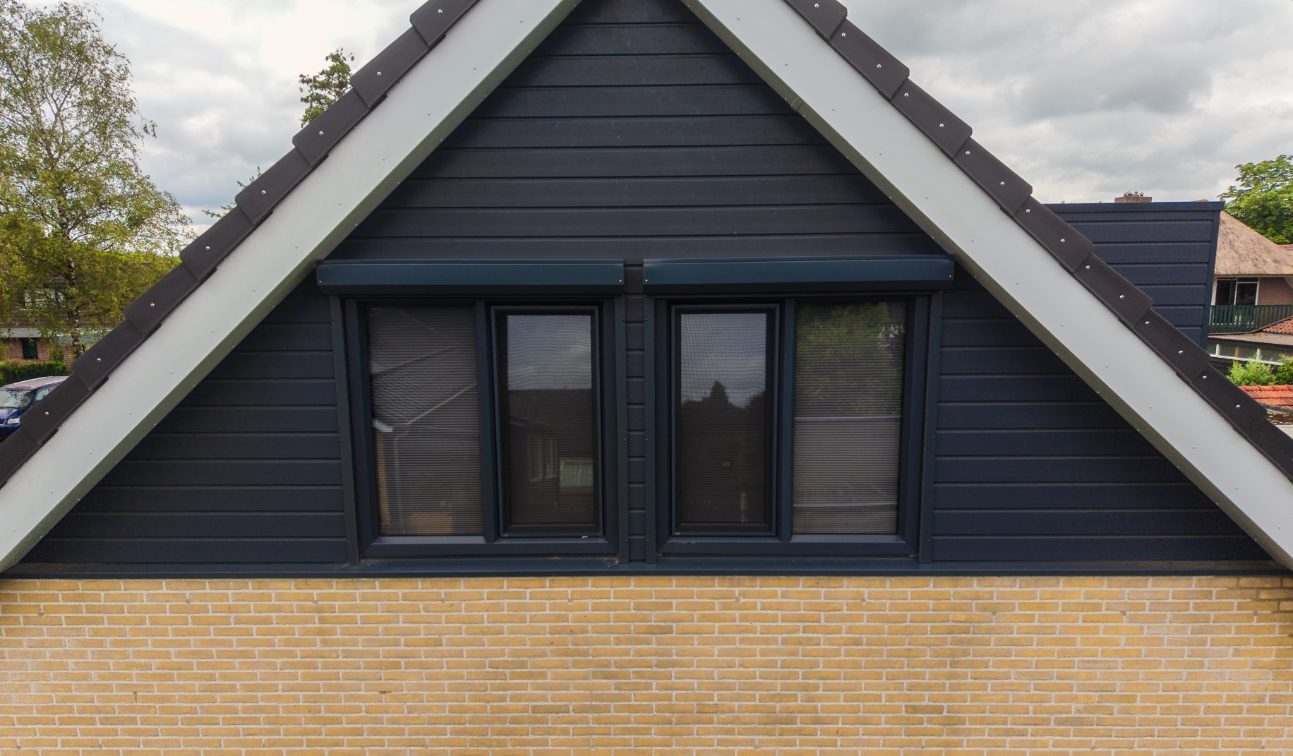 Woning in de steigers met een dak in blauwe folie en een bouwkraan erachter